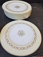 Stack of 10 Wedgwood Sandringham dinner plates showing floral and ribbon border design.