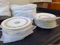 Stack of stacked Wedgwood Sandringham plates and saucers separated by paper protectors