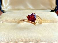 Top view of ring showing heart-shaped red garnet set in yellow gold with bypass design