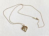 Full view of necklace laid flat showing chain and heart pendant