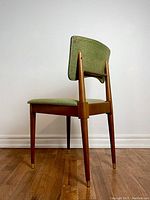 Rear right angled view showing solid wood frame, tapered legs with brass ferrules, and green upholstered seat and backrest