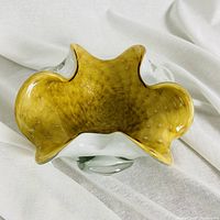 Top angled view of the Murano glass bowl showing yellow interior with gold glitter and ruffled edges