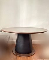 Front view of round mushroom table showing veneer top and black faux leather pedestal