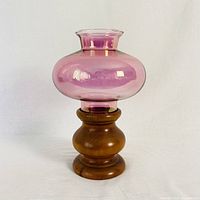 Full view of the candle holder showing the pink glass top and solid cherry wood base.