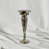 Front view showing full height and shape of a silver plated vase with aged surface tarnish and flaking.