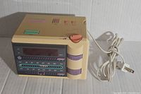 Front side view of vintage beige General Electric PJammer radio showing digital display, tuning dial, AM/FM scales, and attached power cord.