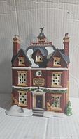 Front side of Dept 56 ceramic Boarding and Lodging School with snow accents and detailed windows and brick façade.