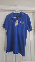 Blue Florida Gators Air Jordan Dri-Fit polo shirt displayed on hanger showing front with logo and Jordan branding.