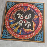 Front view of the KISS Rock And Roll Over album jacket with bold colorful artwork and band member faces.