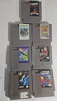 Top side front view showing the front labels of 8 NES cartridges arranged in two columns of four. Titles visible include Arch Rivals, Tetris 2, Mission Impossible, 4x4 Off-Road Racing, Street Fighter, Hockey.
