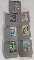 Front view of seven original Nintendo NES game cartridges including Mester Megamix, Cyberball, Combat Simtek, Track & Field II, Othello, Pro Football, and Football.