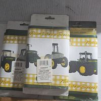 Three packaged John Deere decorative borders with tractor images and yellow gingham print.