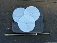 Vintage brass-toned tension pole lamp base with visible spring wear, laid horizontally against pavement