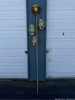 Full view of lamp showing tension pole, top canopy, and all three hanging shades