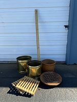 Full lot arrangement including brass cachepots, wooden rolling bases, square bamboo bases, woven basket, and bamboo rods against a door background.