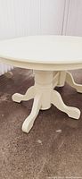 Oval dining table in soft butter yellow with double pedestal base, showing top and base design.
