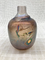 Front view showing the vase's oilslick iridescent surface with colorful embedded threads and abstract patterns under sandcast texture.