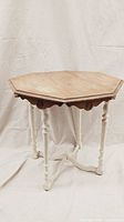 Full view of the vintage octagonal side table showing the two-toned oak top and white distressed legs against a curtain backdrop.