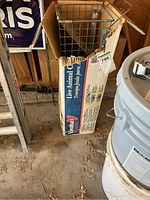 Metal live animal trap box showing brand and product details with visible wear and tear.