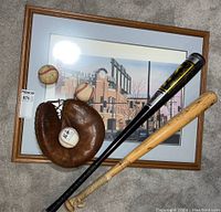 Full lot showing framed Rockies print, two baseball bats, catcher's mitt, and three baseballs