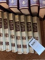 Several volumes of Funk & Wagnalls New Encyclopedia, volumes 23 through 29, showing spine details and titles.