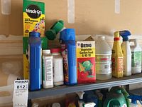 Shelf with various MiracleGro and garden supply products including plant food boxes and liquid bottles