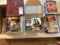 Photo showing the maroon baseball card binder, two boxes filled with loose sports trading cards, and a box with the book 'Big Sticks'.