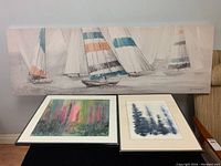 Photo showing two framed watercolours under a large stretched canvas with sailboat imagery.
