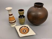 View of all four pottery pieces including the large round brown vase, two smaller banded vases, and diamond-shaped ashtray