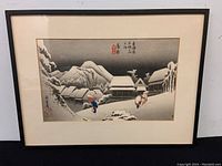 Full view of framed woodblock print in black frame with white matting