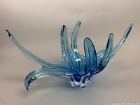 Photo front view showing elongated curved spikes in blue glass with clear thick base.
