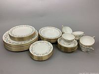 Full view of all dishes stacked by type showing the pattern and quantity: 8 dinner plates, 6 luncheon plates, 7 dessert plates, 6 cereal bowls, and 7 teacups with saucers.