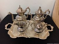 Full set displayed on black background showing all 5 pieces including coffee pot, teapot, sugar bowl with lid, creamer and large tray.