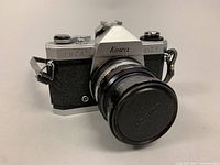 Full view of the vintage Kowa SET R2 camera showing the lens with cap attached and the camera body in silver and black with textured grip.