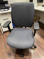 Front view of the grey cloth office desk chair showing seat, backrest, and armrests.
