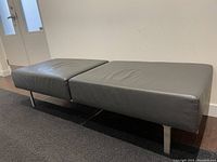 Front angled view showing two-cushion leather top and metal legs