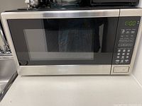 Front view of Danby stainless steel microwave, showing digital keypad and display at right, door closed.