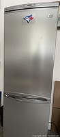 Front view of closed stainless steel refrigerator with digital control panel and sticker
