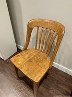 Solid wood wooden chair with vertical slatted backrest, curved top rail, contoured seat and sturdy legs.