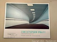 Photo of the rectangular plaque mounted art poster titled "Pedestrian Tunnel" by Christopher Pratt showing an architectural tunnel image and printed exhibition details below.
