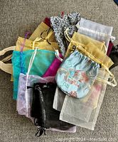 Top view photo showing a variety of preowned jewelry gift bags in multiple colors and materials gathered together.