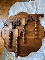 Top view of round wooden low table showing carved decorative edges and four detachable legs laid on top.