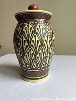 Front view of Teresa Wingar stoneware pottery canister showing intricate slip trail floral and geometric patterns in yellow, brown and burgundy red. Includes lid with knob handle.