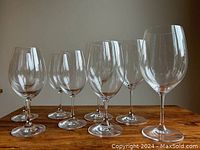Front view of 10 wine glasses in three different sizes arranged in rows showing clear glass quality and smooth finish.