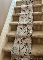 Table runner displayed on a carpeted staircase showing full length and design detail with visible brand tag