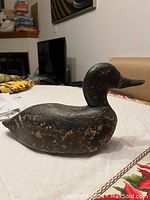 Opposite side view of wooden duck decoy showing consistent paint wear and shape.