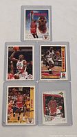 Front sides of 5 Michael Jordan basketball cards showing action photos and portraits