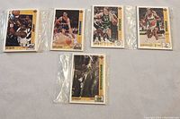 Five individual sets of sealed NBA basketball trading cards on a flat surface.