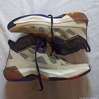 Side view of Air Jordan 37 Beyond Borders shoes showing translucent mesh upper with multi-color accents including beige, black, orange and red.