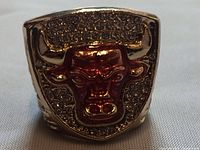 Close-up image of the front of the replica ring showing raised bull logo and rhinestones around it.
